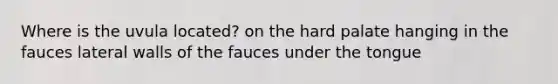 Where is the uvula located? on the hard palate hanging in the fauces lateral walls of the fauces under the tongue