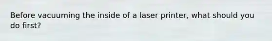 Before vacuuming the inside of a laser printer, what should you do first?