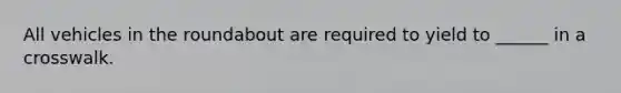 All vehicles in the roundabout are required to yield to ______ in a crosswalk.