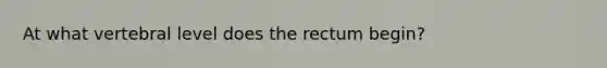 At what vertebral level does the rectum begin?