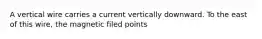 A vertical wire carries a current vertically downward. To the east of this wire, the magnetic filed points