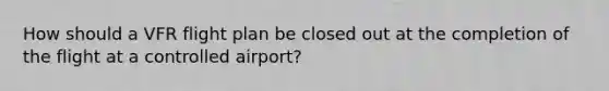 How should a VFR flight plan be closed out at the completion of the flight at a controlled airport?