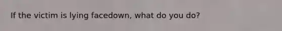 If the victim is lying facedown, what do you do?