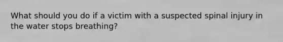 What should you do if a victim with a suspected spinal injury in the water stops breathing?