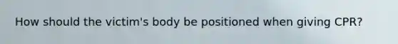 How should the victim's body be positioned when giving CPR?