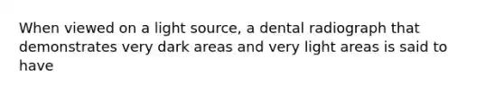 When viewed on a light source, a dental radiograph that demonstrates very dark areas and very light areas is said to have