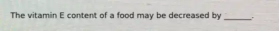 The vitamin E content of a food may be decreased by _______.