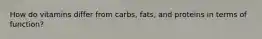 How do vitamins differ from carbs, fats, and proteins in terms of function?