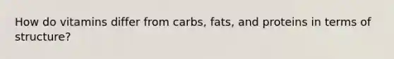 How do vitamins differ from carbs, fats, and proteins in terms of structure?