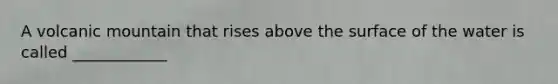 A volcanic mountain that rises above the surface of the water is called ____________