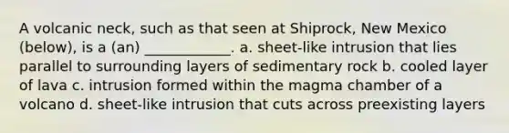 A volcanic neck, such as that seen at Shiprock, New Mexico (below), is a (an) ____________. a. sheet-like intrusion that lies parallel to surrounding layers of sedimentary rock b. cooled layer of lava c. intrusion formed within the magma chamber of a volcano d. sheet-like intrusion that cuts across preexisting layers