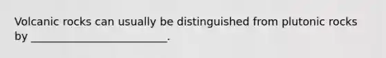 Volcanic rocks can usually be distinguished from plutonic rocks by _________________________.
