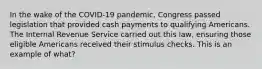 In the wake of the COVID-19 pandemic, Congress passed legislation that provided cash payments to qualifying Americans. The Internal Revenue Service carried out this law, ensuring those eligible Americans received their stimulus checks. This is an example of what?