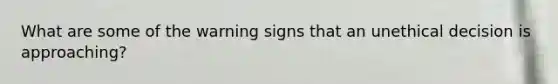 What are some of the warning signs that an unethical decision is approaching?