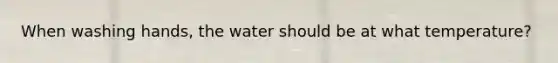 When washing hands, the water should be at what temperature?