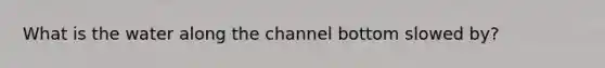 What is the water along the channel bottom slowed by?