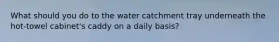 What should you do to the water catchment tray underneath the hot-towel cabinet's caddy on a daily basis?