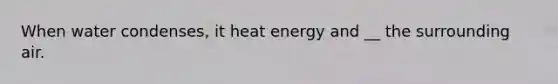 When water condenses, it heat energy and __ the surrounding air.