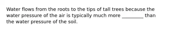 Water flows from the roots to the tips of tall trees because the water pressure of the air is typically much more _________ than the water pressure of the soil.