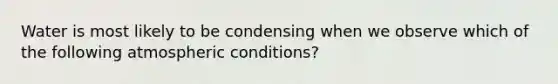 Water is most likely to be condensing when we observe which of the following atmospheric conditions?