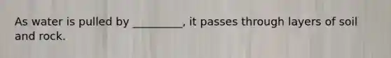 As water is pulled by _________, it passes through layers of soil and rock.