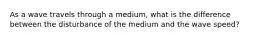 As a wave travels through a medium, what is the difference between the disturbance of the medium and the wave speed?