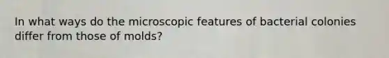 In what ways do the microscopic features of bacterial colonies differ from those of molds?