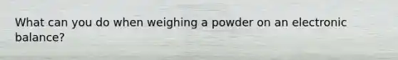 What can you do when weighing a powder on an electronic balance?