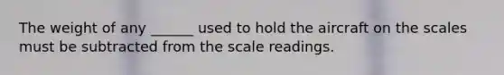 The weight of any ______ used to hold the aircraft on the scales must be subtracted from the scale readings.