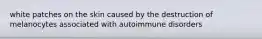 white patches on the skin caused by the destruction of melanocytes associated with autoimmune disorders