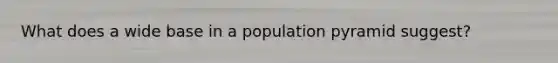 What does a wide base in a population pyramid suggest?