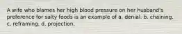 A wife who blames her high blood pressure on her husband's preference for salty foods is an example of a. denial. b. chaining. c. reframing. d. projection.