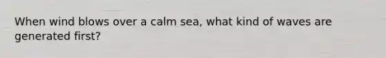 When wind blows over a calm sea, what kind of waves are generated first?