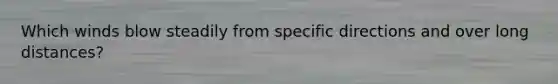 Which winds blow steadily from specific directions and over long distances?