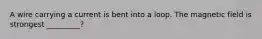 A wire carrying a current is bent into a loop. The magnetic field is strongest _________?