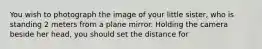 You wish to photograph the image of your little sister, who is standing 2 meters from a plane mirror. Holding the camera beside her head, you should set the distance for