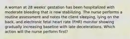 A woman at 28 weeks' gestation has been hospitalized with moderate bleeding that is now stabilizing. The nurse performs a routine assessment and notes the client sleeping, lying on the back, and electronic fetal heart rate (FHR) monitor showing gradually increasing baseline with late decelerations. Which action will the nurse perform first?