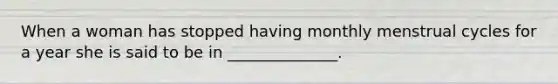 When a woman has stopped having monthly menstrual cycles for a year she is said to be in ______________.