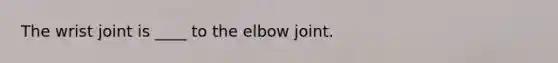 The wrist joint is ____ to the elbow joint.