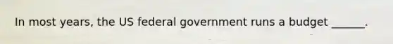 In most years, the US federal government runs a budget ______.