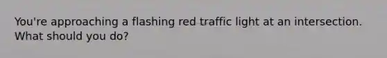 You're approaching a flashing red traffic light at an intersection. What should you do?