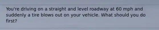 You're driving on a straight and level roadway at 60 mph and suddenly a tire blows out on your vehicle. What should you do first?