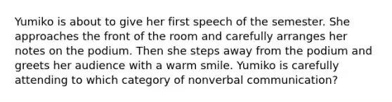 Yumiko is about to give her first speech of the semester. She approaches the front of the room and carefully arranges her notes on the podium. Then she steps away from the podium and greets her audience with a warm smile. Yumiko is carefully attending to which category of nonverbal communication?